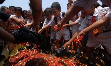 Pelajar SD Negeri 05 Pagi Kalideres menabur bunga di makam Putri Nur Fauziah yang menjadi korban pembunuhan, Kalideres, Jakarta Barat, Senin (5/10). 