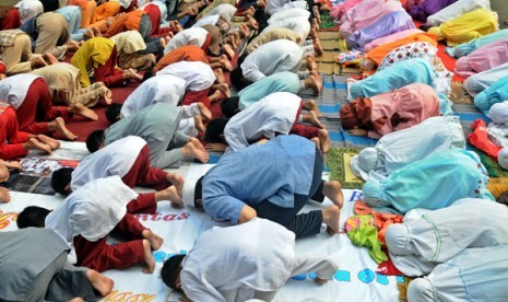 Pelajar SDN 03 dan 04 Gondangdia Jakarta sedang melakukan sholat Dhuha di halaman sekolahnya.