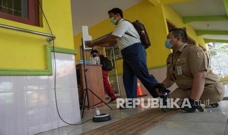 Pelajar Sekolah Luar Biasa (SLB) didampingi guru ASN mencuci tangan saat akan memasuki ruang kelas di SLB Negeri Kabupaten Batang, Jawa Tengah, Senin (27/9/2021). SLB Negeri Batang melakukan simulasi Pembelajaran Tatap Muka (PTM) sebanyak 50 persen kehadiran dengan tetap menerapkan protokol kesehatan yang telah ditentukan untuk pelajar difabel.