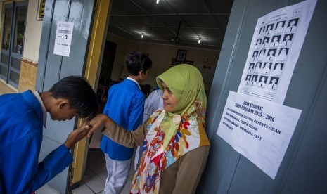 Pelajar Sekolah Menengah Pertama (SMP) memberi salam kepada guru sebelum melaksanakan Ujian Nasional (UN) 2016 di SMP N 2 Pakem, Sleman, DI Yogyakarta, Senin (9/5). 