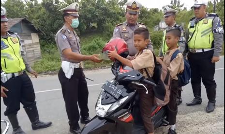 Ilustrasi polisi mengedukasi pelajar yang melanggar aturan.