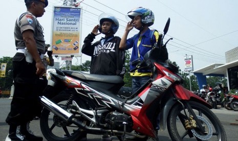 Pelajar yang melanggar lalu lintas diberi sanksi menyanyikan lagu kebangsaan Indonesia Raya dihadapan petugas saat Operasi Zebra di Jombang, Jawa Timur, Kamis (298/10).