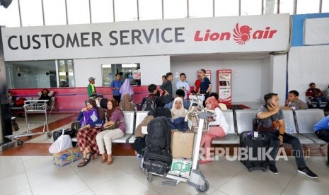 Pelanggan duduk di dekat konter Lion Air di Bandara Internasional Soekarno-Hatta di Tangerang, Senin (29/10/2018) 