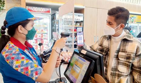 Pelanggan melakukan transaksi pembelian dengan menunjukkan kode QRIS BNI Mobile Banking di Gerai Indomaret PIK, Kamis (11/8/2022). Dalam upaya memperkuat Ekosistem Cashless, BNI dan Indomaret menghadirkan pembayaran nontunai dengan menggunakan QRIS BNI Mobile Banking. Super app BNI ini telah mampu melakukan pembayaran belanjaan di toko Indomaret dengan hanya menunjukkan QRIS yang tersedia pada aplikasi BNI Mobile Banking ke kasir Indomaret.