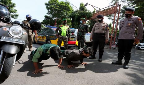 Pelanggar menjalani hukuman indisipliner saat terjaring razia penegakan PPKM Darurat di Kota Blitar, Jawa Timur, Rabu (14/7/2021). Razia yang dilanjutkan sidang di tempat secara daring terhadap masyarakat yang melanggar ketentuan PPKM Darurat tersebut melibatkan aparat gabungan Polri, TNI, dan Satpol PP dengan tujuan meningkatkan kepatuhan masyarakat terhadap ketentuan PPKM Darurat yang diharapkan mampu menekan penyebaran COVID-19.