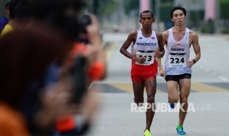 Pelari Indonesia Agus Prayogo bersaing ketat dengan pelari Singapura Soh Rui Yong saat bertanding pada nomor lari marathon SEA Games XXIX Kuala Lumpur di Putrajaya, Malaysia, Sabtu (19/8).