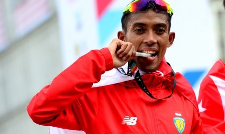 Pelari Indonesia Agus Prayogo menggigit medali perak saat pengalungan medali pada nomor lari marathon SEA Games XXIX Kuala Lumpur di Putrajaya, Malaysia, Sabtu (19/8). Agus meraih medali perak dengan catatan waktu dua jam 27 menit 16 detik sementara emas diraih pelari Singapura Soh Rui Yong dengan waktu dua jam 24 menit 55 detik dan perunggu diraih pelari Malaysia Muhaizar dengan dua jam 35 menit 05 detik.