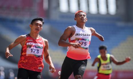 Pelari Indonesia Rizal Bagus Saktyono (tengah) dan Nur Ferry Pradana (kiri) saat mencapai garis finis pada nomor lari 100 meter putra T47 ASEAN Para Games 2022 di Stadion Manahan, Solo, Jawa Tengah, Senin (1/8/2022). 