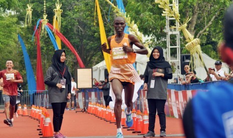 Pelari Kenya, Geoffrey Birgen saat menyentuh garis finish yang pertama pada kategori Full Marathon Open Male, Borobudur Marathon 2018 Powered by Bank Jateng, di Taman Lumbini, Kompleks Candi Borobudur, Kabupaten Magelang, Jawa Tengah, Ahad (18/11). Ia mencatatkan waktu tercepat   2 jam 20 menit 10 detik.