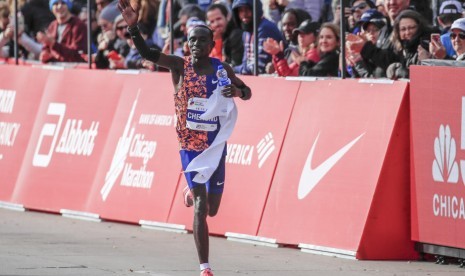 Pelari Lawrence Cherono dari Kenya melalukan victory lap usai menuntaskan Chicago Marathon, 13 Oktober 2019.