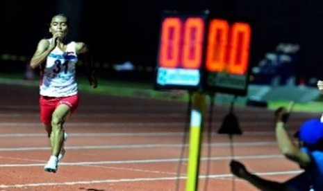 Pelari putri Indonesia, Triyaningsih, berlari menuju garis finis pada pertandingan lari nomor 10 ribu meter SEA Games 2011 di Stadion Atletik Jakabaring Sports City, Palembang, Sabtu (13/11).