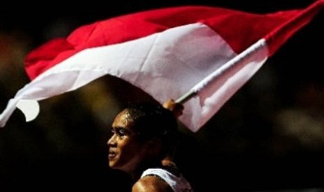 Pelari putri Indonesia Triyaningsih, melakukan selebrasi usai finis diurutan pertama pada pertandingan lari nomor 5000 meter, cabang Atletik Sea Games ke 26 di Stadion Atletik Jakabaring Sports City, Palembang, Sumatera Sealatan, Senin (14/11). 