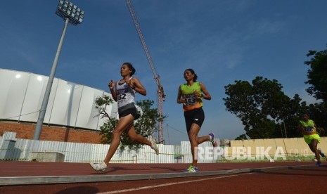 Pelari putri NTT Olivia Sadi (kanan) dan pelari DKI Jakarta Odekta Vina berlari pada nomor 10 ribu meter putri Kejurnas Atletik di Stadion Rawamangun, Jakarta, Kamis (7/12). 