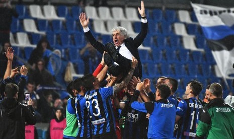 Pelatih Atalanta, Gian Piero Gasperini (atas), melakukan selebrasi bersama pemainnya usai memenangkan laga Serie A Italia lawan Sassuolo Calcio di Reggio Emilia pada 26 Mei 2019. Kemenangan ini memastikan Atalanta meraih tiket Liga Champions.