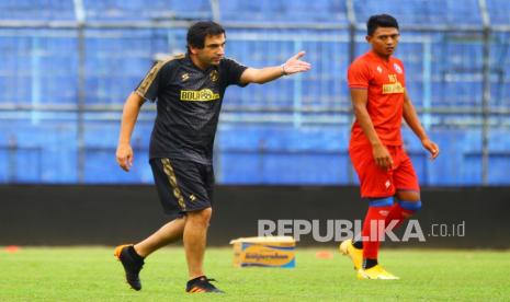 Pelatih Arema FC Eduardo Almeida (kiri) memberi instruksi pada anak asuhnya saat memimpin latihan.