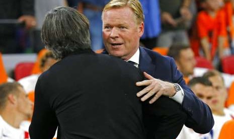 Pelatih Belanda Ronald Koeman (kanan) memeluk pelatih Jerman Joachim Loew.