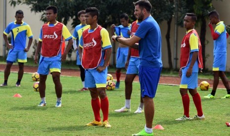 Pelatih Bhayangkara FC Simon McMenemy (ketiga kanan) memimpin anak asuh nya berlatih di Lapangan Mapolda Jawa Timur, Surabaya, pada awal April. 