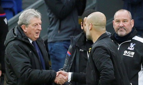 Pelatih Crystal Palace, Roy Hodgson (kiri) bersalaman dengan pelatih Manchester City, Pep Guardiola pada laga Liga Primer di Selhurst Park, London, Ahad (31/12). Laga berakhir imbang 0-0.