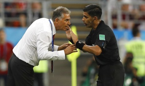 Pelatih Iran Carlos Queiroz (kiri) mengajukan keluhan kepada wasit Enrique Caceres dalam laga melawan Portugal.