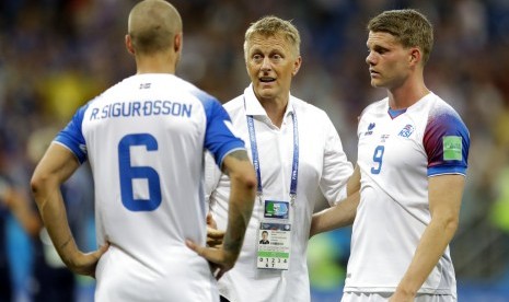 Pelatih Islandia, Heimir Hallgrimsson (tengah), menghibur para pemainnya seusai tersingkir dari Piala Dunia 2018.