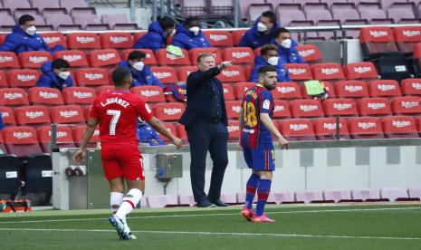 Pelatih kepala Barcelona Ronald Koeman, tengah, memberikan instruksi dari garis samping saat pertandingan sepak bola La Liga Spanyol antara FC Barcelona dan Granada di stadion Camp Nou di Barcelona, ??Spanyol, Kamis, 29 April 2021.