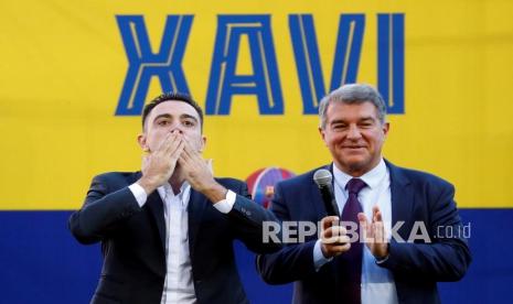  Pelatih kepala baru FC Barcelona, Xavi Hernandez (kiri), memberikan ciuman kepada penggemar di sebelah Presiden FC Barcelona, Joan Laporta, saat presentasi di stadion Camp Nou di Barcelona, Spanyol, Senin (8/11/2021). Xavi Hernandez meninggalkan klub Al-Sadd Qatar untuk memimpin FC Barcelona selama sisa musim ini dan dua musim lagi. 