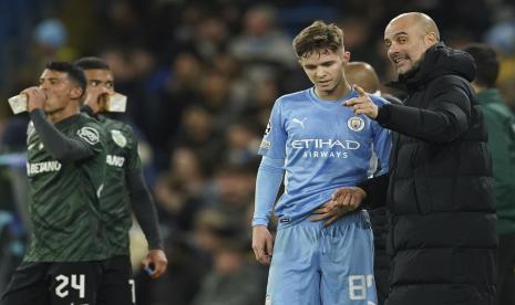 Pelatih Manchester City Pep Guardiola berbicara dengan pemain mudanya, James McAtee (kiri), selama pertandingan Liga Primer Inggris musim lalu.