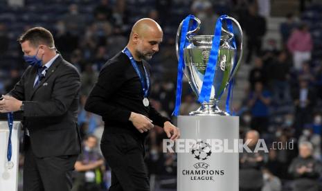 Pelatih kepala Manchester City Pep Guardiola berjalan melewati trofi di akhir pertandingan final Liga Champions antara Manchester City dan Chelsea di Stadion Dragao di Porto, Portugal, Ahad (30/5) pagi WIB. Chelsea memenangkan pertandingan 1-0. 