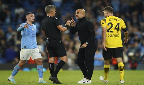 Pelatih Manchester City Pep Guardiola, kiri tengah, berdebat dengan wasit Daniele Orsato selama pertandingan sepak bola Grup G Liga Champions antara Manchester City dan Borussia Dortmund di Stadion Etihad di Manchester, Inggris, Rabu, 14 September 2022. Man City menang 2-1 di laga itu.