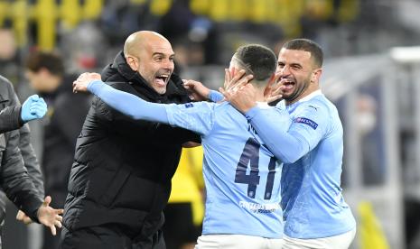 Pelatih kepala Manchester City Pep Guardiola merayakan dengan pencetak gol Phil Foden Manchester City selama pertandingan sepak bola leg kedua perempat final Liga Champions antara Borussia Dortmund dan Manchester City di stadion Signal Iduna Park di Dortmund, Jerman, Rabu, 14 April 2021