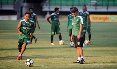 Pelatih kepala Persebaya Surabaya Djadjang Nurdjaman (kanan) mengamati anak asuhnya yang sedang menjalani latihan.