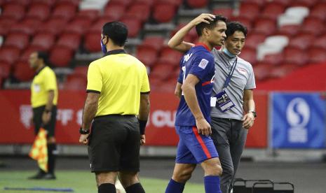 Pelatih kepala Singapura, Tatsuma Yoshida, kanan, menghibur Safuwan Baharudin usai mendapatkan kartu merah pada pertandingan leg kedua semifinal Piala AFF Suzuki Cup 2020 antara Indonesia dan Singapura di Singapura, Sabtu 25 Desember 2021. 