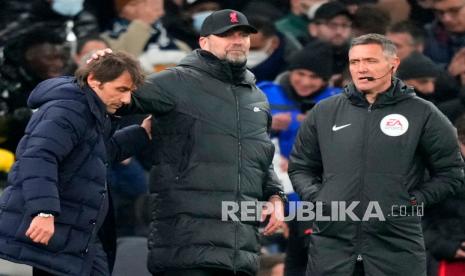  Pelatih kepala Tottenham Antonio Conte (kiri) dan manajer Liverpool Jurgen Klopp (tengah) pada akhir pertandingan sepak bola Liga Inggris antara Tottenham Hotspur dan Liverpool di Stadion Tottenham Hotspur di London,  Ahad (19/12/2021).