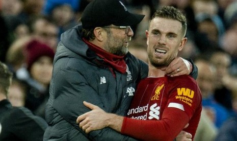 Pelatih Liverpool Juergen Klopp (kiri) memeluk kapten tim Jordan Henderson usai laga melawan Southampton di Liga Inggris.