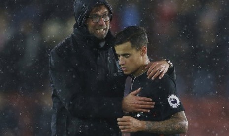 Pelatih Liverpool, Juergen Klopp (kiri) menyemangati Philippe Coutinho seusai laga Liga Primer Inggris lawan Southampton di stadion Saint Mary, Sabtu (19/11). Laga berakhir imbang tanpa gol.