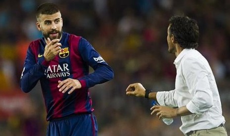 Pelatih Luis Enrique tengah berbicara kepada Gerard Pique 