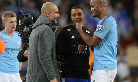 Pelatih Manchester City Pep Guardiola berbicara dengan Vincent Kompany usai pertandingan melawan Leicester, Selasa (7/5) dini hari WIB.