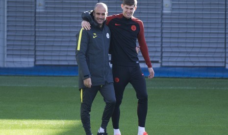 Pelatih Manchester City, Pep Guardiola dan bek John Stones pada sebuah sesi latihan klub.