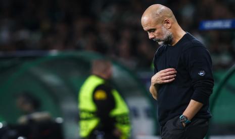 Pelatih Manchester City Pep Guardiola tertunduk.