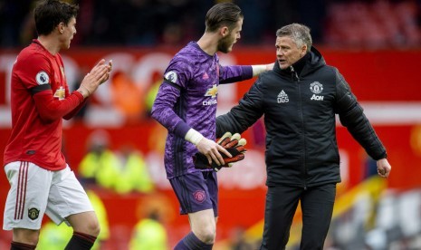 Pelatih Manchester United (MU), Ole Gunnar Solskjaer (kanan) dan Kiper MU, David de Gea, bersalaman usai laga.