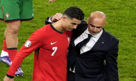 Pelatih Portugal Roberto Martinez (kanan) berjalan bersama Cristiano Ronaldo setelah Portugal dikalahkan Prancis 3-5 lewat adu penalti pada babak delapan besar Euro 2024.