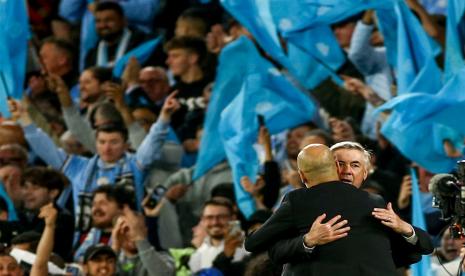 Pelatih Real Madrid Carlo Ancelotti memeluk pelatih Manchester City Pep Guardiola selepas pertandingan leg kedua semifinal Liga Champions antara kedua tim yang berakhir dengan kemenangan City 4-0 di Stadion Etihad, Manchester, Kamis (18/5/2023) dini hari WIB.