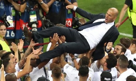  Pelatih Real Madrid Zinedine Zidane dilempar ke udara oleh para pemain Los Blancos usai meraih gelar juara Liga Champions di Stadion San Siro, Milan, Ahad (29/5). (AP/Alessandra Tarantino)