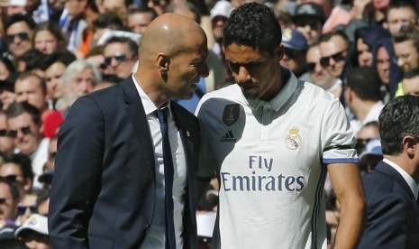 Pelatih Real Madrid Zinedine Zidane (kiri) berbicara dengan Raphael Varane.