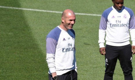 Pelatih Real Madrid Zinedine Zidane (kiri) tertawa saat menyaksikan para pemainnya berlatih.