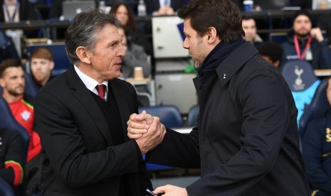 Pelatih Southampton, Claude Puel (kiri) bersalaman dengan pelatih Tottenham Hotspur, Mauricio Pochettino pada laga Liga Primer di White Hart Lane, Ahad (19/3). Southampton kalah 1-2.