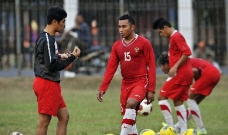 Pelatih Tim Sepakbola Indonesia Selection Nil Maizar (kiri) memberikan pengarahan saat sesi latihan.