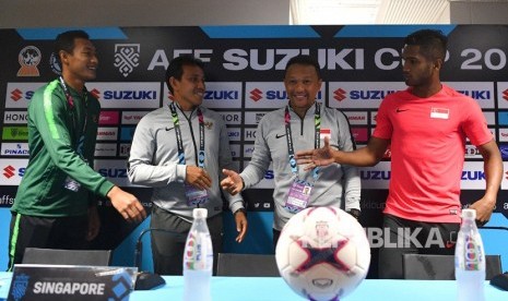 Pelatih timnas Indonesia Bima Sakti (kedua kiri) dan pemain timnas Indonesia Hansamu Yama (kiri) berbincang dengan pelatih timnas Singapura Fandi Ahmad (kedua kanan) serta pemain timnas Singapura Hariss Harun saat konferensi pers piala AFF 2018 di Stadion Nasional, Singapura, Kamis (8/11/2018).