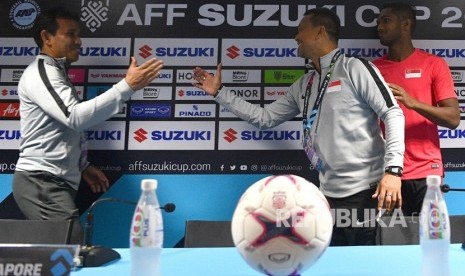 Pelatih timnas Indonesia Bima Sakti (kiri) berbincang dengan pelatih timnas Singapura Fandi Ahmad (tengah) serta pemain timnas Singapura Hariss Harun (kanna) saat konferensi pers piala AFF 2018 di Stadion Nasional, Singapura, Kamis (8/11/2018). 