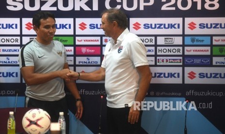 Pelatih timnas Indonesia Bima Sakti (kiri) berjabat tangan dengan Pelatih Thailand Milovan Rajevac (kanan) dalam sesi konferensi pers menjelang laga lanjutan Piala AFF 2018 di Stadion Nasional Rajamangala, Bangkok, Thailand, Jumat (16/11/2018).